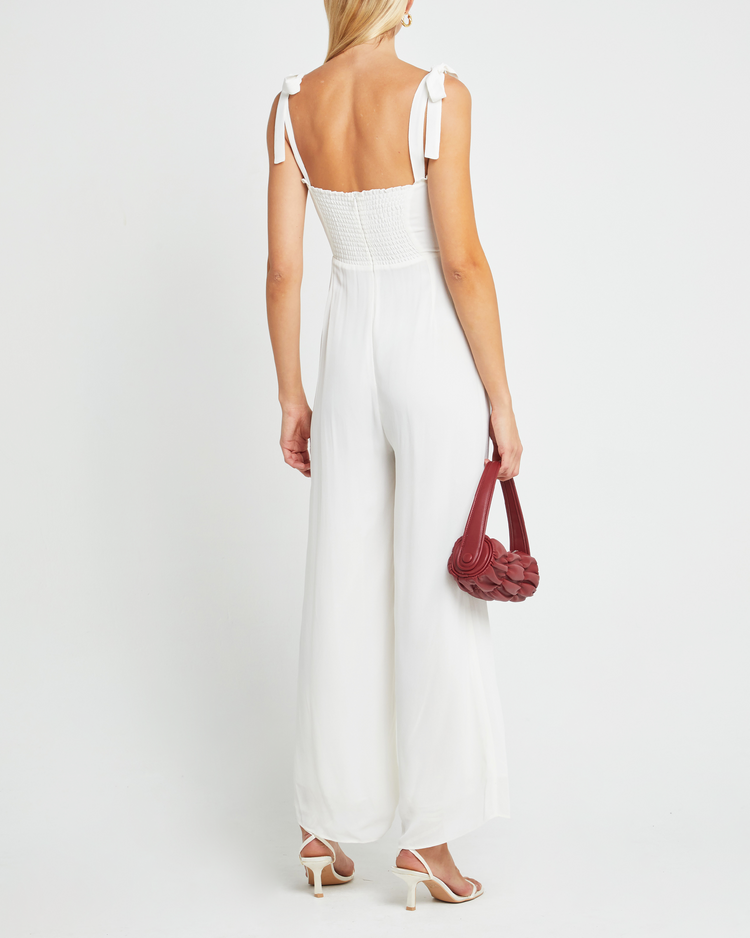 Second image of Blair Jumpsuit, a white jumpsuit with straight-leg lined pants, adjustable tie straps, cup detail, neckline ruffles, and a back zipper